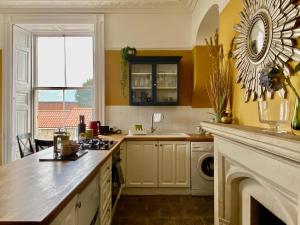 a kitchen with a counter and a sink and a fireplace at The Georgian Manor Apartment - Central Frome in Frome
