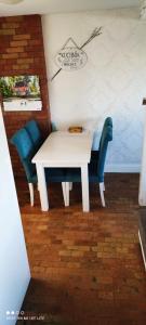 una mesa blanca y sillas azules en una habitación en Apartament z widokiem Słubice, en Słubice