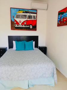 um quarto com uma cama e um quadro de uma carrinha em The Beach Break Hotel em El Zonte
