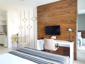 a bedroom with a bed with a desk and a tv at Fusion Hplus Express + in Brasilia