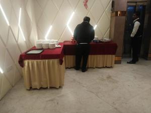 Ein Mann steht an einem Tisch in einem Zimmer in der Unterkunft Hotel D SilverLeaf in Lucknow