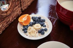 a white plate of oatmeal with bananas and blueberries at St Christopher's The Inn - London Bridge in London