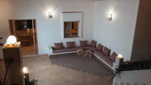 a living room with a couch and a table at Villa avec piscine Asilah, terrain de foot privative in Asilah