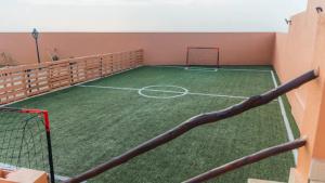 a tennis court with a net in a room at Villa avec piscine Asilah, terrain de foot privative in Asilah