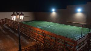 a tennis court in an empty arena at night at Villa avec piscine Asilah, terrain de foot privative in Asilah
