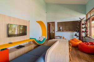 Carmel Charme Resort في أكويراز: غرفة معيشة مع أريكة وتلفزيون