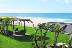 a garden with a tent and a beach at Carmel Charme Resort in Aquiraz