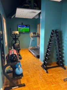 una habitación con un gimnasio con dos máquinas de correr y un televisor en Quality Hotel Olavsgaard, en Skjetten