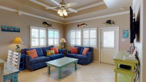 a living room with a blue couch and a table at SFH201 Newly Renovated Ground Floor Townhome, Shared Pool, Near Beach in Port Aransas