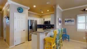 a kitchen with yellow chairs and a counter top at SFH201 Newly Renovated Ground Floor Townhome, Shared Pool, Near Beach in Port Aransas