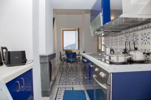 a kitchen with blue and white tiles and a stove at Infinity Sea View House in Amalfi