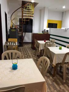 een eetkamer met tafels en stoelen en een tv bij Seascape Lodging House in Coron