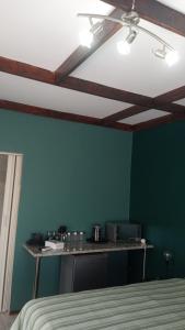 ein Zimmer mit einer grünen Wand mit einem Tisch. in der Unterkunft Paul & Mollie's Guest House in Brits