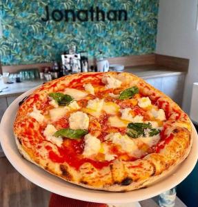 pizzę siedzącą na talerzu na stole w obiekcie Jonathan Bed&Pizza w mieście Komárom