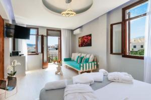 ein Wohnzimmer mit einer blauen Couch und einem Fernseher in der Unterkunft Diamond Luxury Suites in Chania