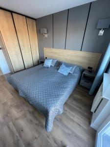 a bedroom with a large bed with a wooden headboard at Apartament Bielik in Międzyzdroje