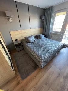 una camera con un grande letto con testiera in legno di Apartament Bielik a Międzyzdroje