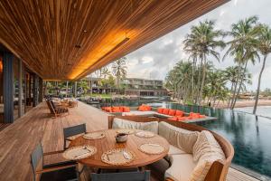 an outdoor patio with a table and chairs and a pool at Carmel Taíba Exclusive Resort in Taíba