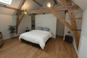 Schlafzimmer mit einem Bett in einem Zimmer mit Holzbalken in der Unterkunft B&B 't Burreken in Schorisse