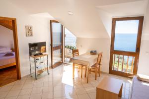 a living room with a table and a view of the ocean at Apartments Liza Cavtat in Cavtat
