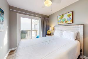 ein Schlafzimmer mit einem großen weißen Bett mit einem Fenster in der Unterkunft Heavenly Days by Meyer Vacation Rentals in Fort Morgan