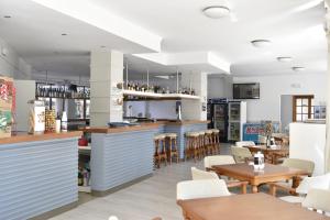un restaurant avec un bar, des tables et des chaises dans l'établissement Apartamentos Arcos Playa, à S'illot