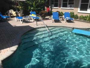 a swimming pool with a blue chair and blue chairs at INN LEATHER GUEST HOUSE-GAY MALE ONLY in Fort Lauderdale