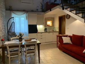 a living room with a table and a red couch at Holiday Home Mattiuzi in Nedeščina +28 photos