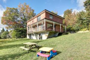 una casa su una collina con tavolo e tavolo da picnic di Chalet le Harfang- SPA-Bord Lac Beaulac by Galaxia a Chertsey