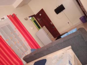a living room with a couch and a mirror at Warm and Homely Studio Apartment in Mombasa +8 photos