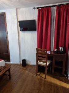 a room with a desk and a red curtain at Hotel El Tajo & SPA in Ronda