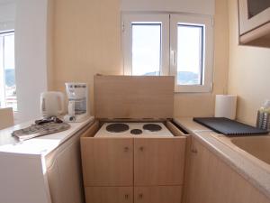 una pequeña cocina con fogones y fregadero en Lux Sea Studio - Porto Rafti, en Porto Rafti