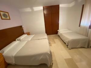 a hotel room with two beds and a window at Hotel Casabermeja in Casabermeja