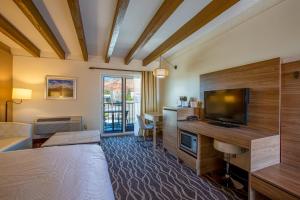 um quarto de hotel com uma cama e uma televisão de ecrã plano em Dreamcatcher Inn of Sedona em Sedona