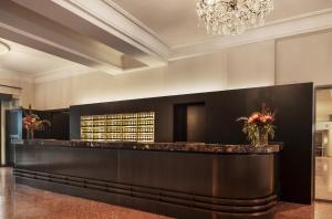 eine Hotellobby mit einer Bar und einem Kronleuchter in der Unterkunft Eden Hotel Wolff in München