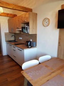 a kitchen with a table and a clock on the wall at Apartmán Sýkorka in Hartmanice