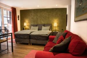 una camera con un letto e un divano rosso di Village Apartment with Matterhorn View a Zermatt