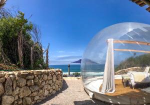 a glass dome on a beach with the ocean at Seeplaas Guesthouse in Groot Brak Rivier
