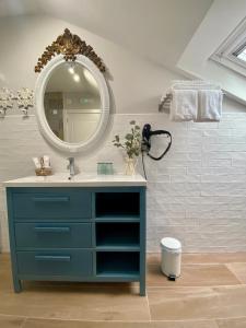 W łazience znajduje się niebieska toaletka i lustro. w obiekcie Villaprado w mieście Cambados