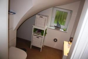 Cette petite chambre dispose de toilettes et d'une fenêtre. dans l'établissement Ferienhaus Bullerbü, à Bedekaspel