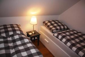 two beds in a room with a lamp on a table at Ferienhaus Bullerbü in Bedekaspel