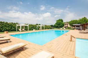 una grande piscina con terrazza in legno e un piscina con idromassaggio di Casa Gioia a Brigolo