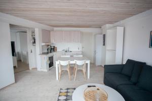 a living room with a couch and a table and a kitchen at Cozy / Nordic House / Baker / Svartifossur in Tórshavn