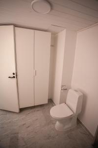 baño blanco con aseo y armario en Cozy / Nordic House / Baker / Svartifossur, en Tórshavn