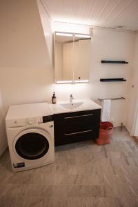 y baño con lavadora y lavamanos. en Cozy / Nordic House / Baker / Svartifossur, en Tórshavn