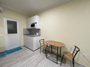 a kitchen with a table and chairs in a room at Flower House in the City Center! in Pristina