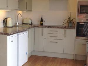 a kitchen with white cabinets and a counter top at PORTHOLES in Ventnor