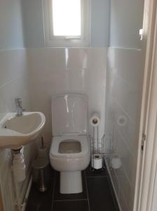 a bathroom with a toilet and a sink and a window at PORTHOLES in Ventnor