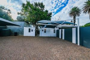 a house with white doors and umbrellas at Rose Acres Guest House in Parys