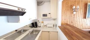 una pequeña cocina con fregadero y microondas en Beaux petits appartements, en La Calamine